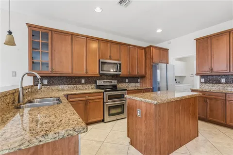 a kitchen with stainless steel appliances granite countertop a sink a stove and a refrigerator