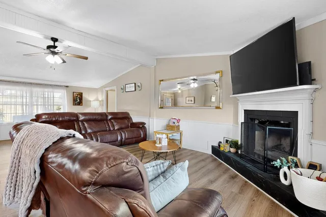 a living room with furniture a flat screen tv and a fireplace