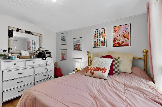 a bedroom with a bed and a view of kitchen