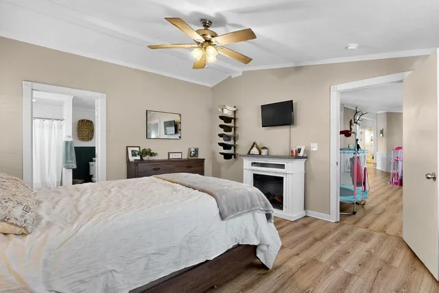 a spacious bedroom with a bed and a flat screen tv