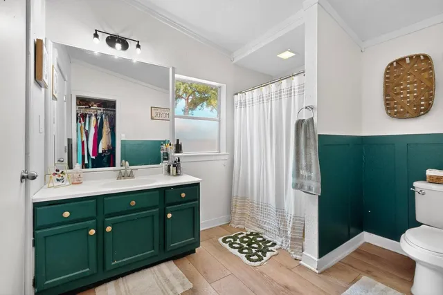 a bathroom with a sink a toilet a mirror and shower