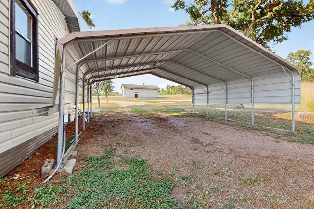 a view of backyard with wooden fence and large trees