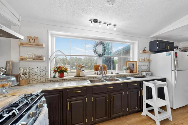 a kitchen with a sink a stove and cabinets