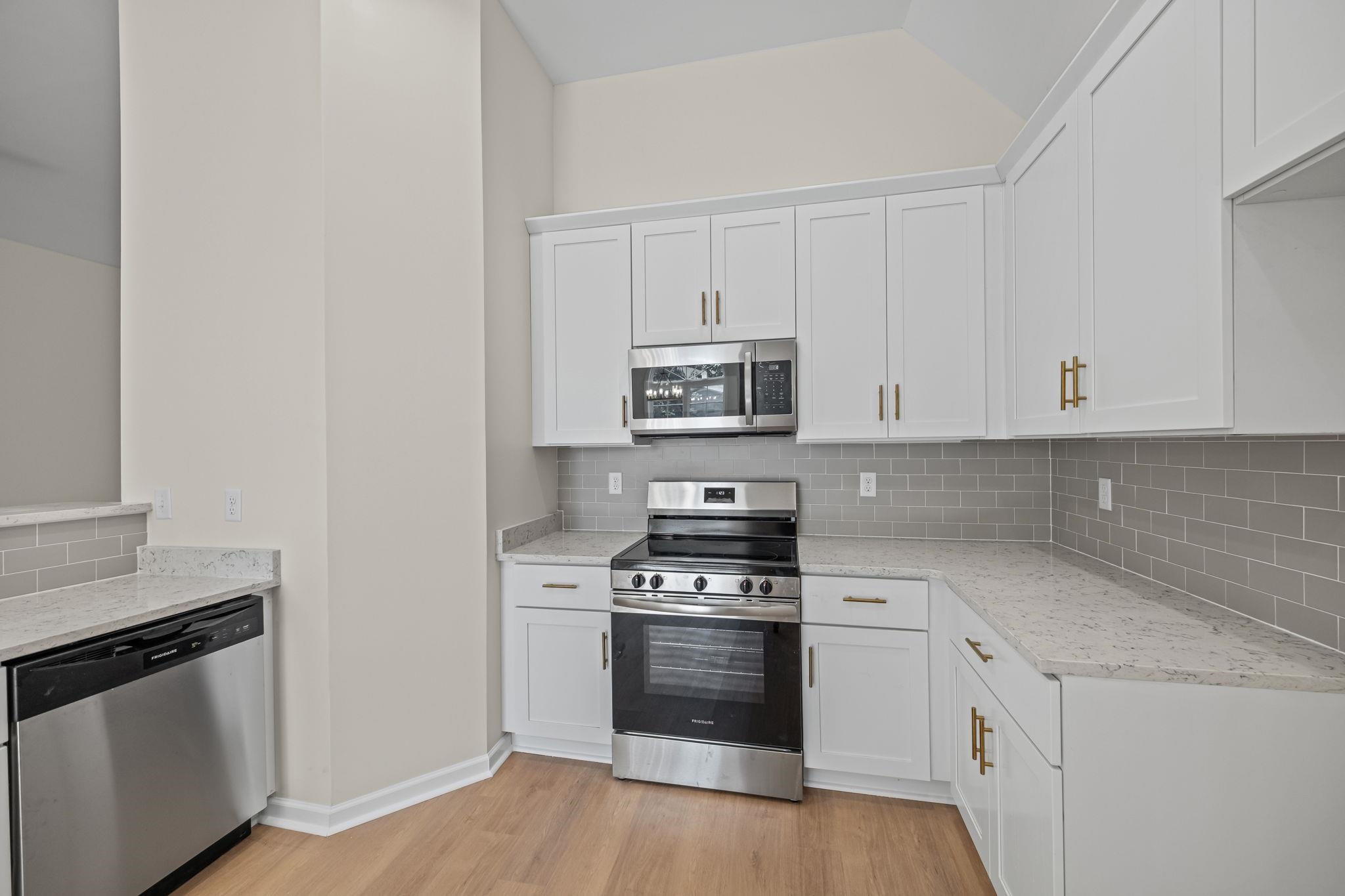 8670 Valmont Circle Memphis, TN 38016 - Photo 14 of 33 Kitchen featuring appliances with stainless steel finishes, decorative backsplash, white cabinetry, and light wood finished floors