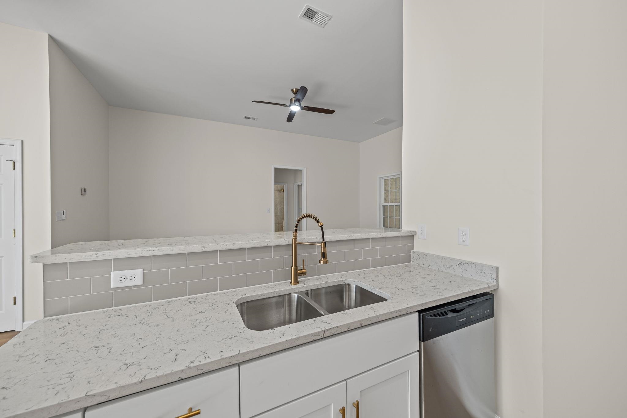 8670 Valmont Circle Memphis, TN 38016 - Photo 16 of 33 Kitchen featuring light stone counters, stainless steel dishwasher, white cabinets, a peninsula, and ceiling fan
