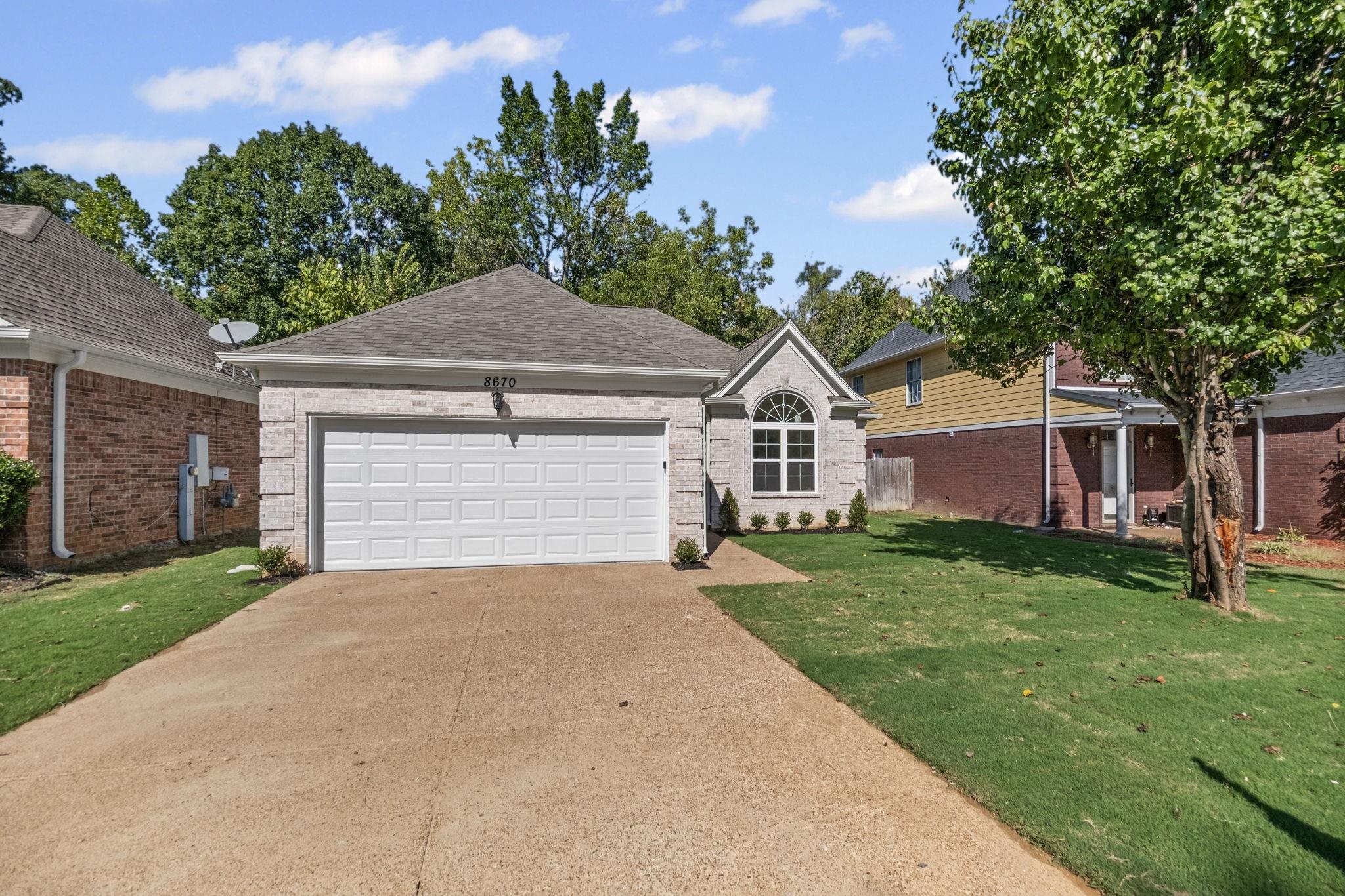 8670 Valmont Circle Memphis, TN 38016 - Photo 2 of 33 Single story home featuring brick siding, concrete driveway, roof with shingles, and an attached garage