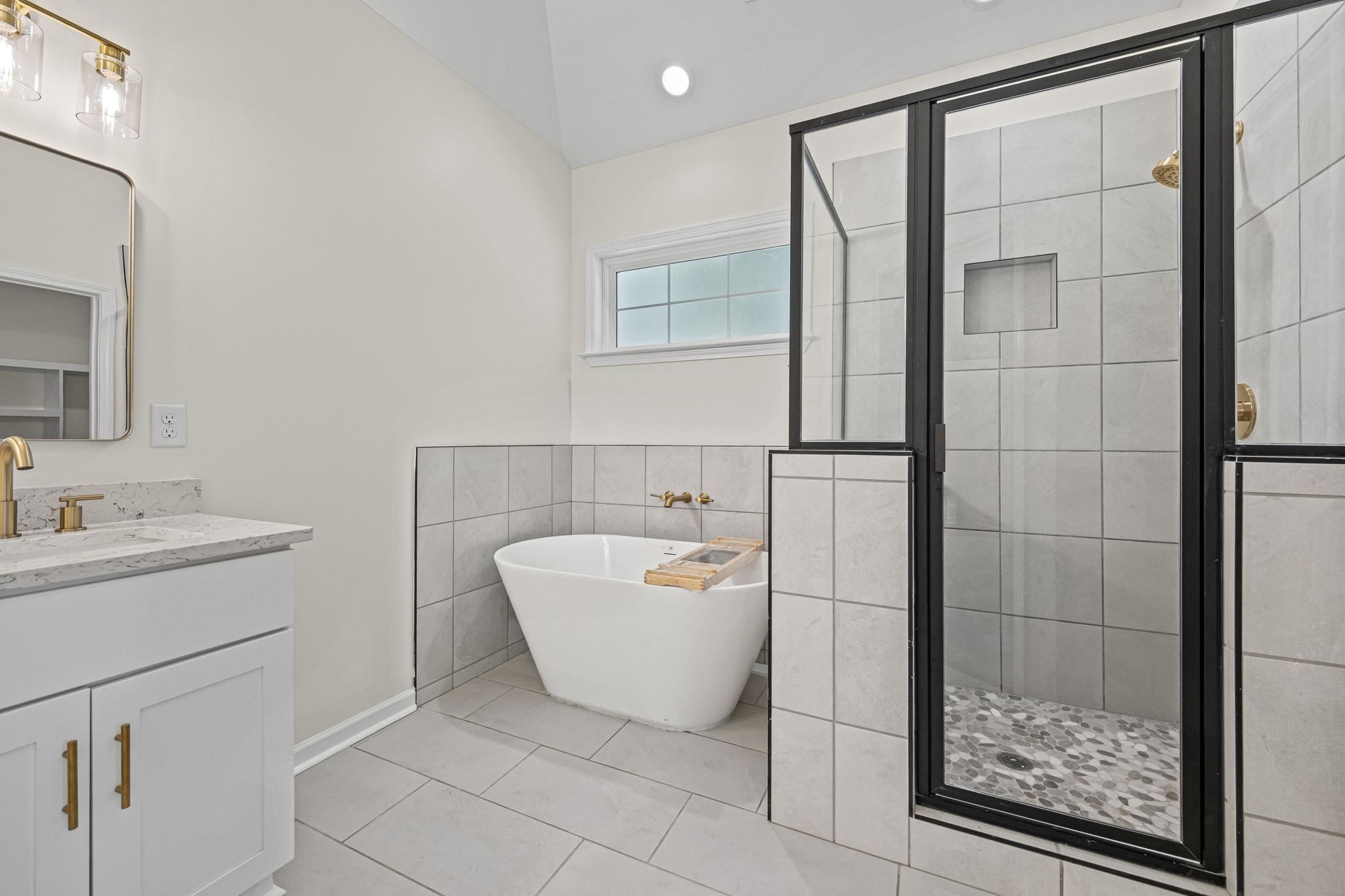 8670 Valmont Circle Memphis, TN 38016 - Photo 25 of 33 Full bath with vanity, a stall shower, a freestanding tub, tile walls, and recessed lighting
