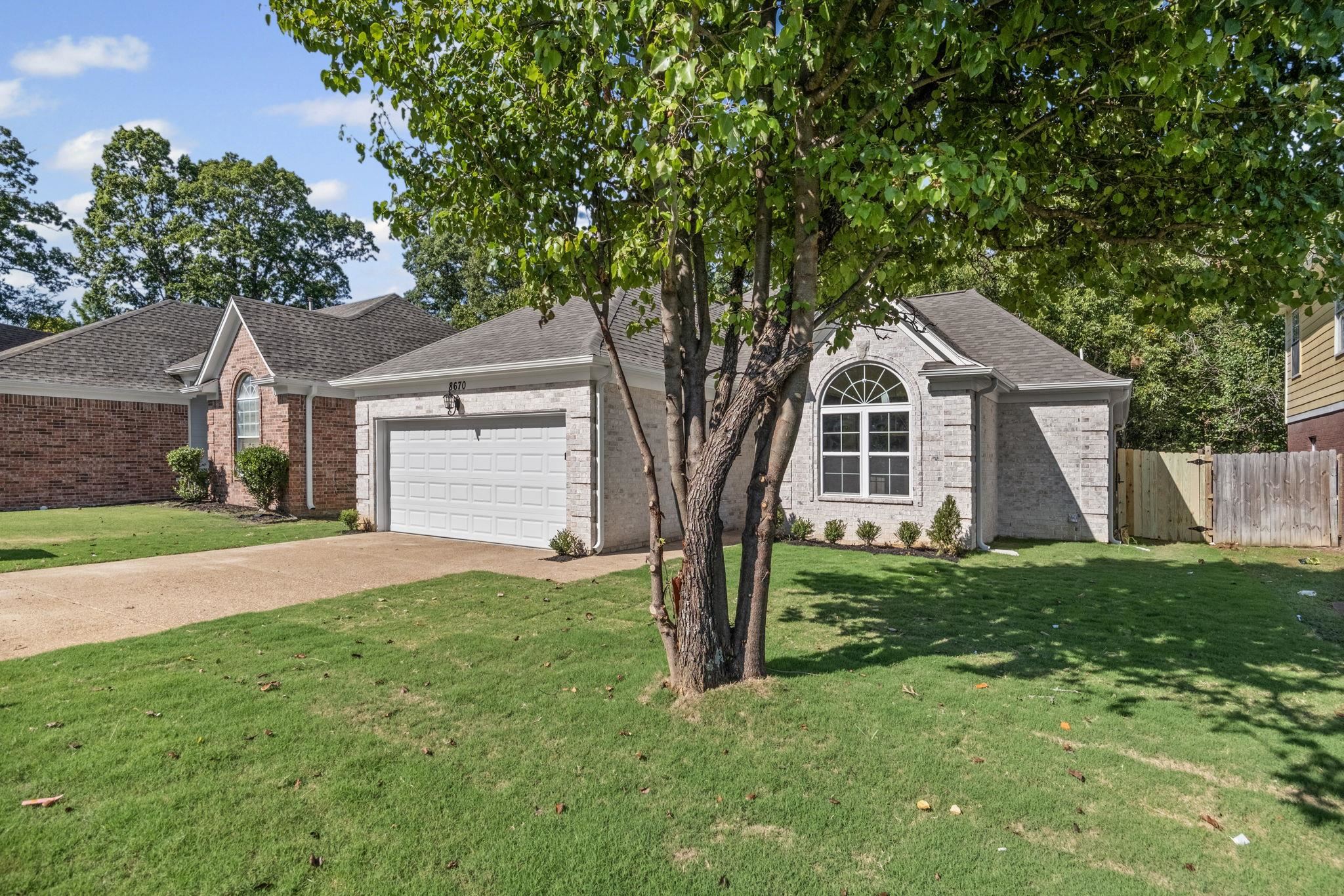 8670 Valmont Circle Memphis, TN 38016 - Photo 33 of 33 View of front of house with driveway, a garage, brick siding, and roof with shingles