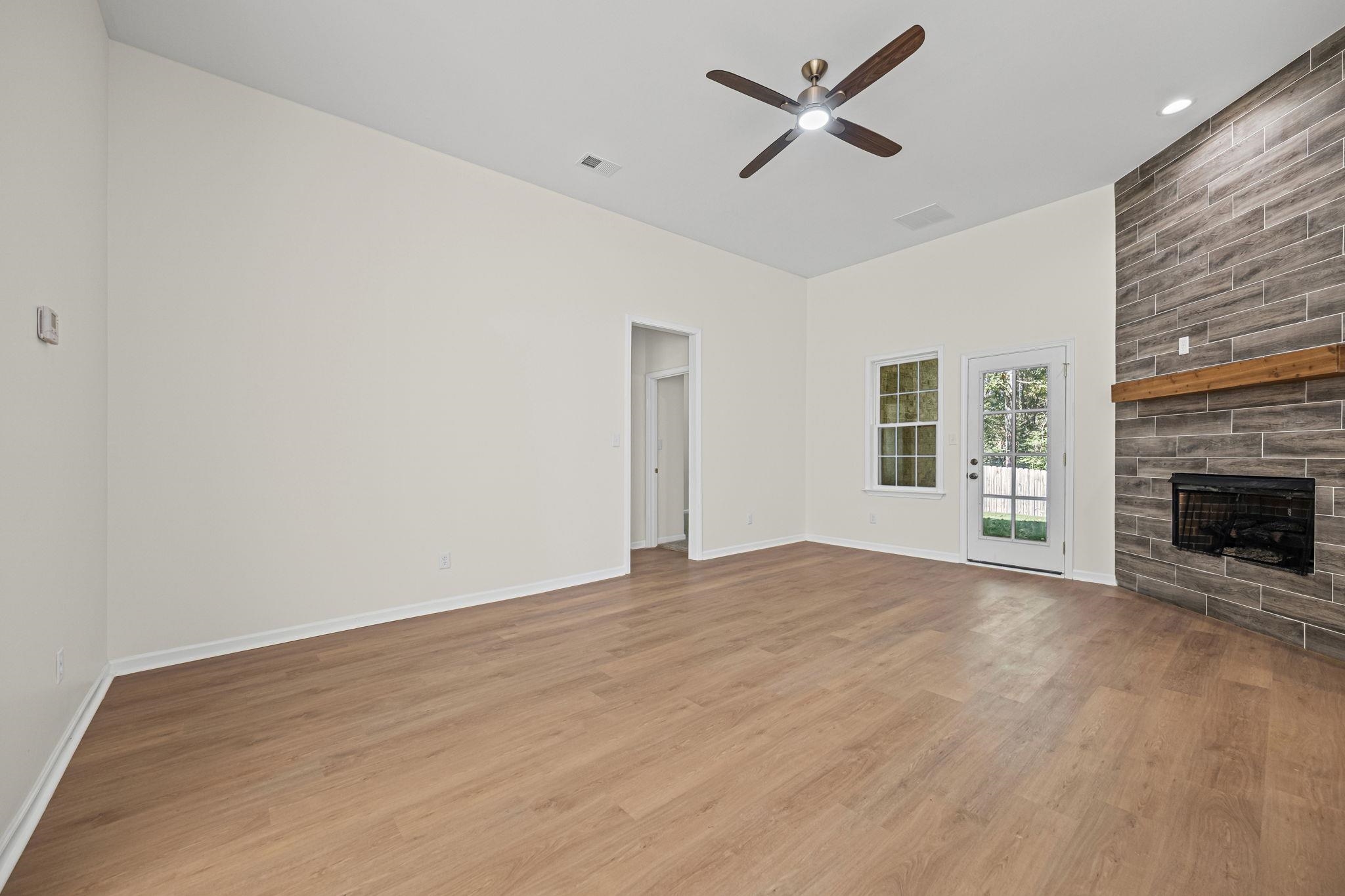 8670 Valmont Circle Memphis, TN 38016 - Photo 6 of 33 Unfurnished living room featuring a large fireplace, light wood-type flooring, ceiling fan, and recessed lighting