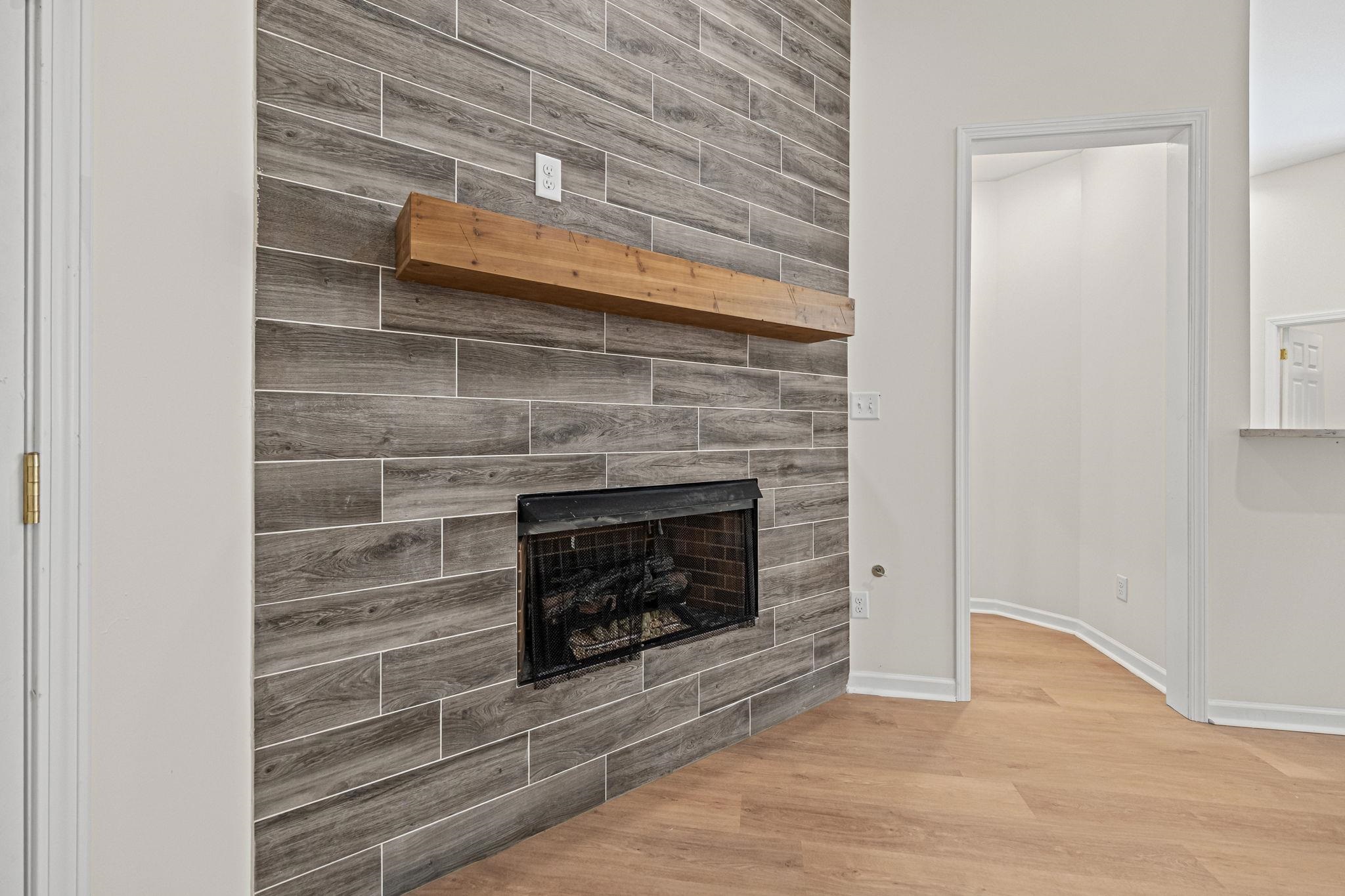 8670 Valmont Circle Memphis, TN 38016 - Photo 7 of 33 Unfurnished living room featuring wood finished floors and a tile fireplace