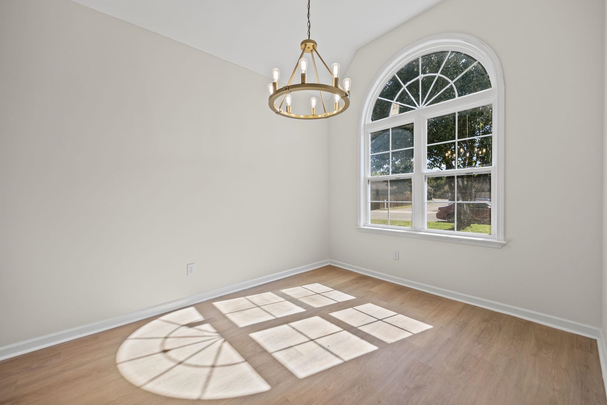 8670 Valmont Circle Memphis, TN 38016 - Photo 10 of 33 Unfurnished dining area featuring light wood-style floors, a chandelier, and lofted ceiling