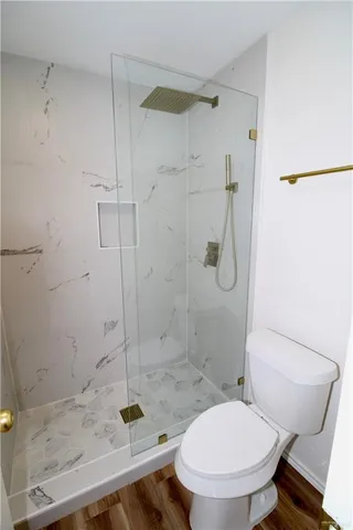 a bathroom with a granite countertop toilet a sink and shower