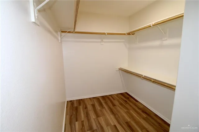 a view of walk in closet with empty racks