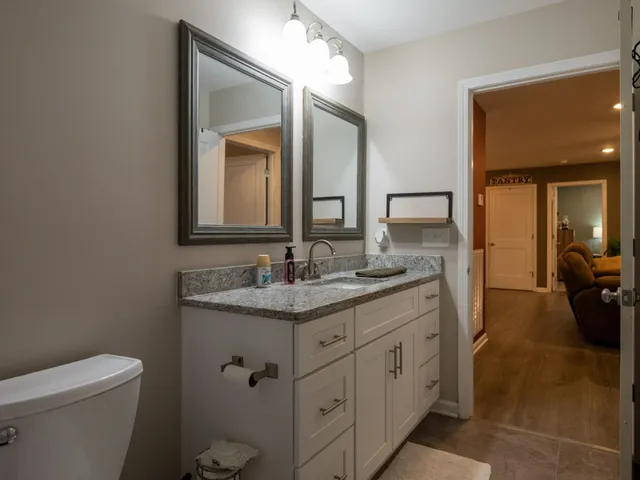 a en suite bathroom with a granite countertop sink and a mirror