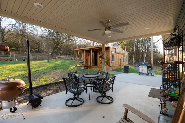 a view of a patio with table and chairs potted plants with wooden floor and fence