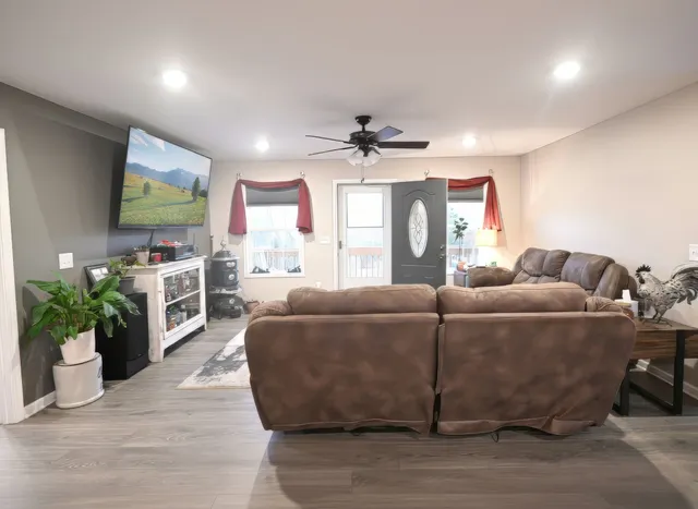 a living room with furniture a chandelier and a flat screen tv