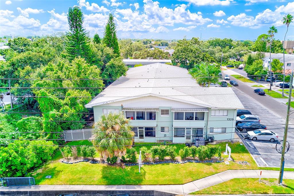 1329 Drew Street, Unit 4 Clearwater, FL 33755 - Photo 28 of 34 a view of a white house with a big yard plants and large trees