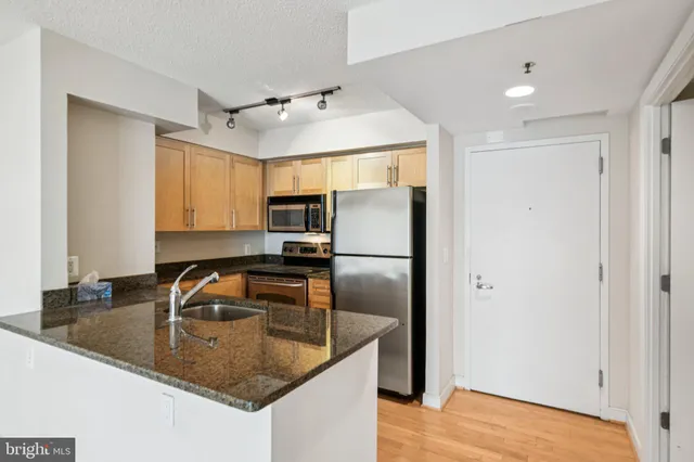 a kitchen with kitchen island a counter top space appliances and a sink