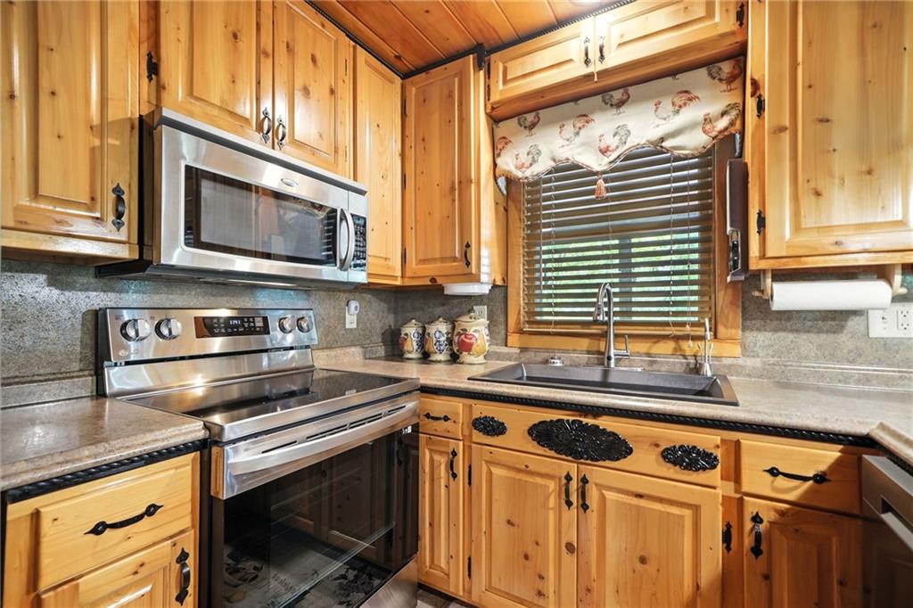59 Bear Track Trail Morganton, GA 30560 - Photo 10 of 37 a kitchen with stainless steel appliances granite countertop a sink a stove and a microwave