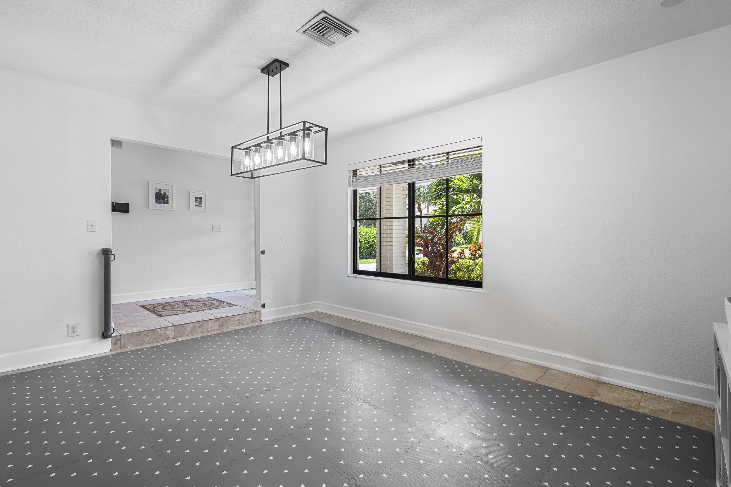 1948 Southwest 36th Avenue Delray Beach, FL 33445 - Photo 16 of 40 an empty room with windows and chandelier