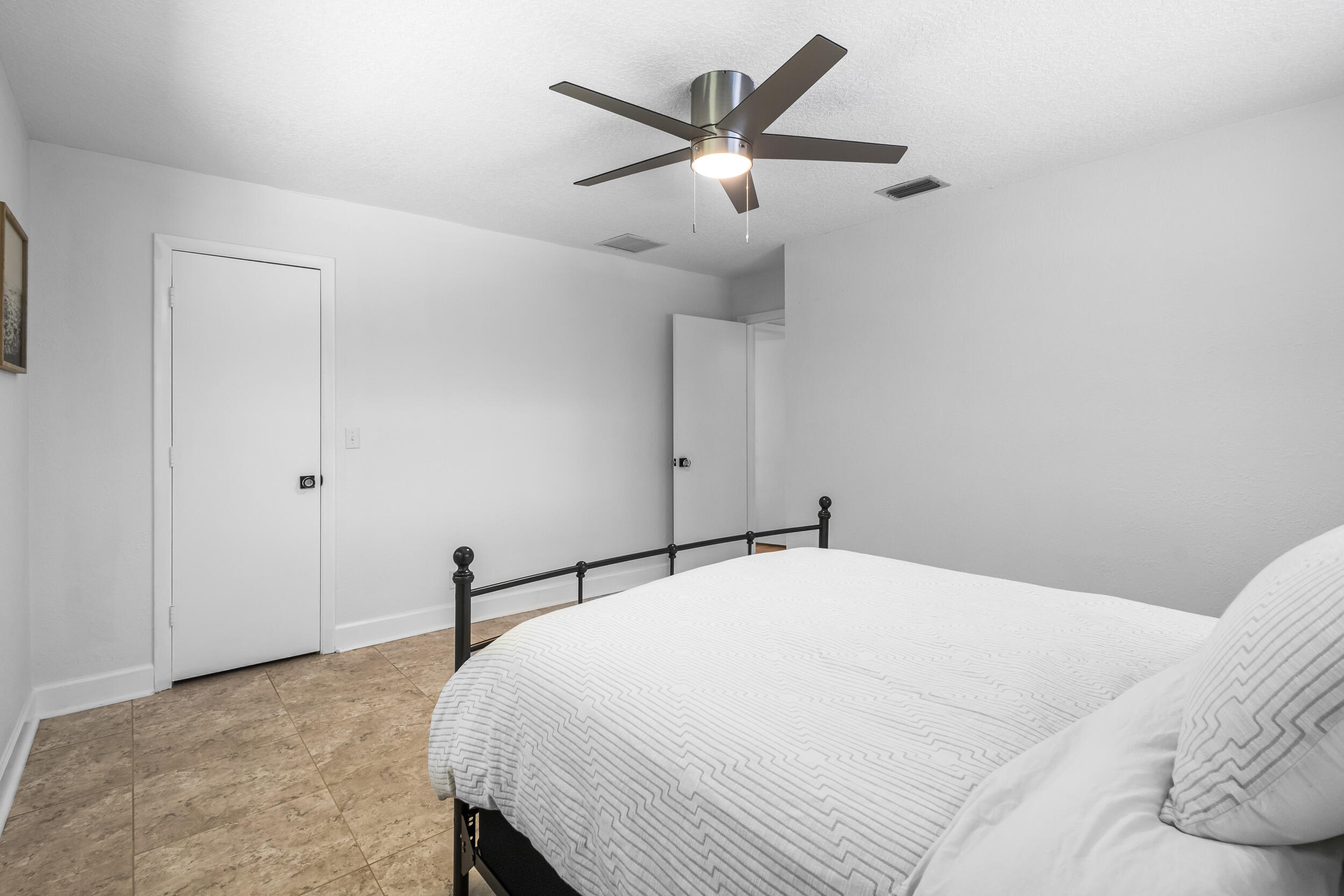 1948 Southwest 36th Avenue Delray Beach, FL 33445 - Photo 28 of 40 a bedroom with a large bed and a ceiling fan