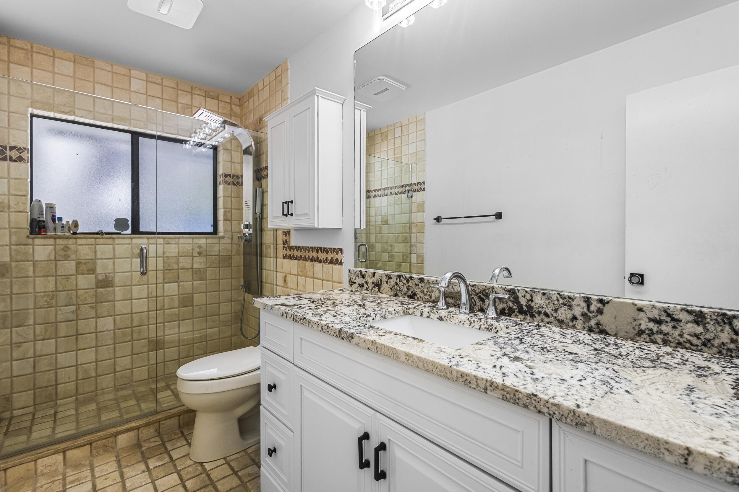 1948 Southwest 36th Avenue Delray Beach, FL 33445 - Photo 32 of 40 a bathroom with a granite countertop sink a toilet and a mirror