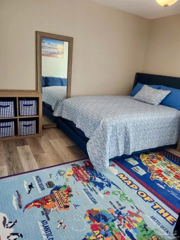 a bedroom with a bed and a painting on the wall