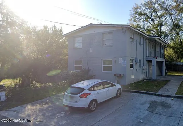 a car parked in front of white house