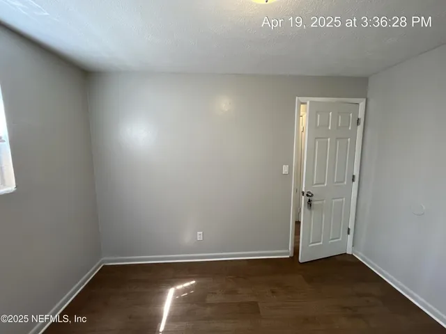 an empty room with wooden floor and closet