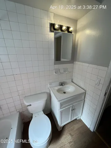 a bathroom with a toilet sink and mirror