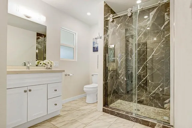 a bathroom with a shower toilet and sink