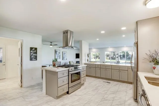 a kitchen with stainless steel appliances granite countertop a stove a sink and a refrigerator