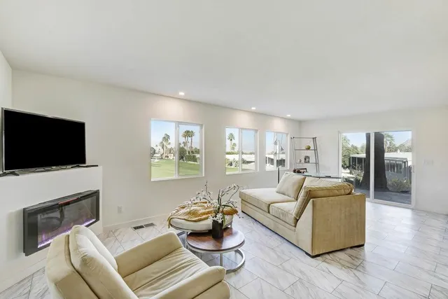 a living room with furniture a flat screen tv and a fireplace