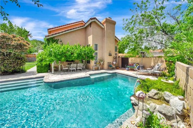 a view of backyard with swimming pool and sitting area