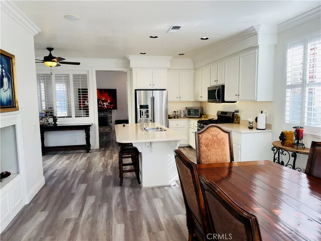 a kitchen with microwave a refrigerator and chairs