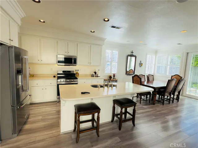 a living room with furniture kitchen view and a refrigerator