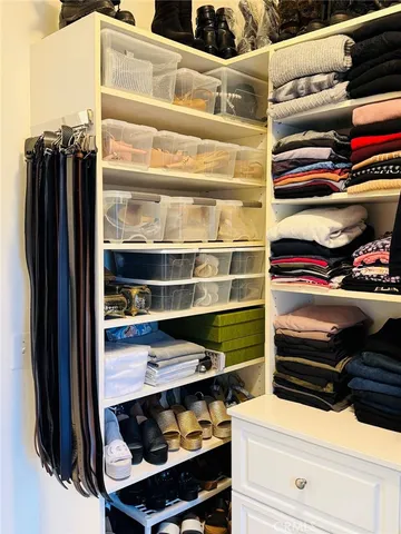 a view of walk in closet with clothes and shoes