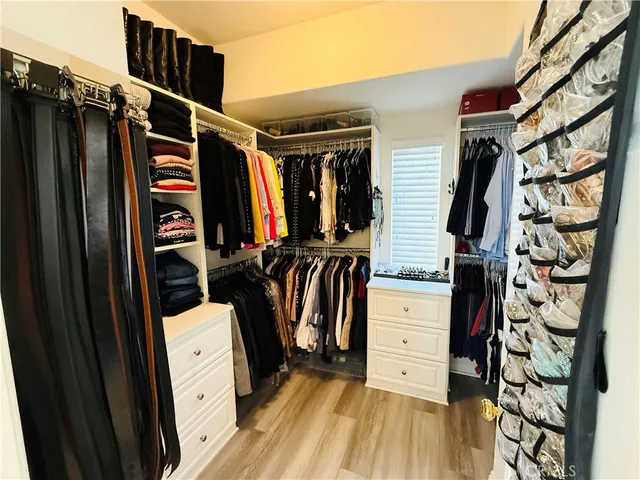 a view of walk in closet with clothes and shoes