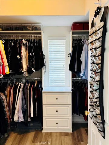 a view of walk in closet with clothes and shoes