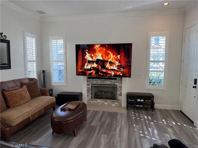 a living room with furniture a flat screen tv and a fireplace
