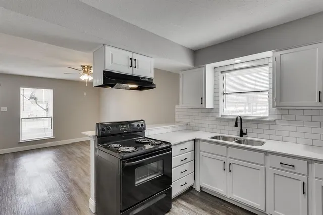 a kitchen with cabinets appliances a sink and a window