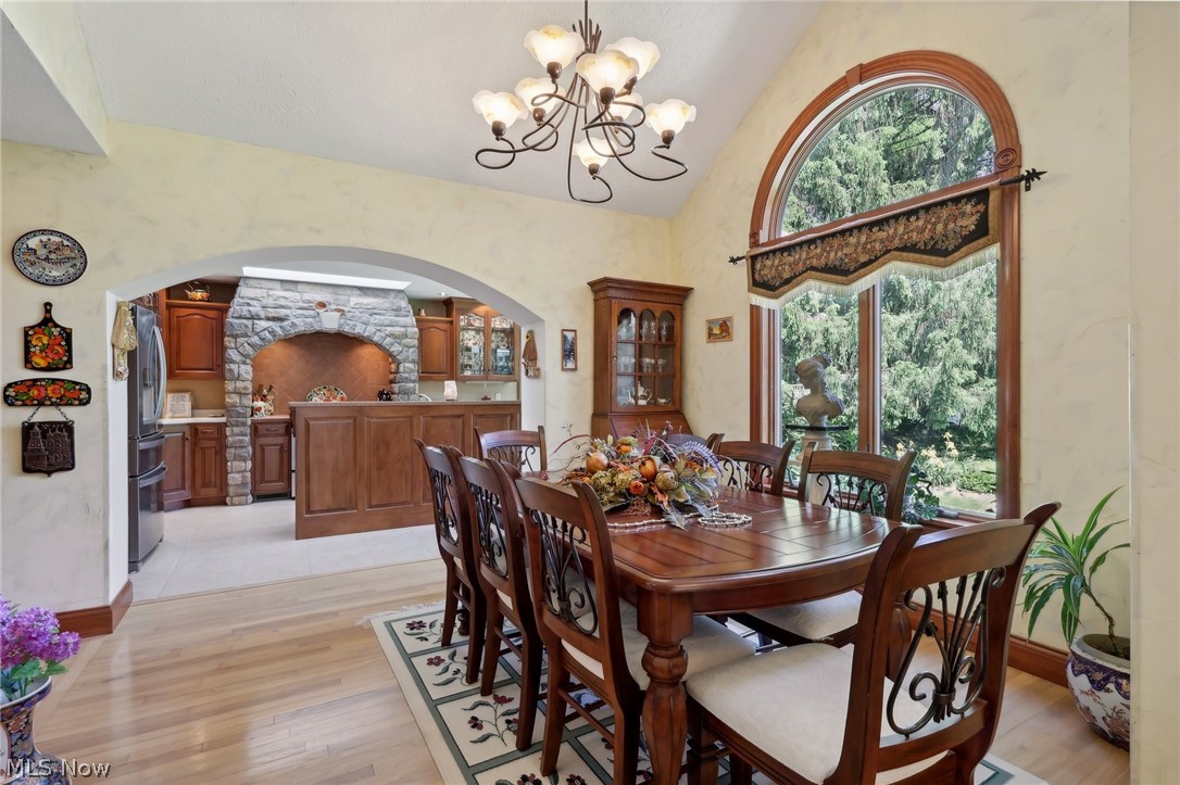 1534 West Comet Road Clinton, OH 44216 - Photo 20 of 43 Dining space with a chandelier, wood- flooring, and vaulted ceiling