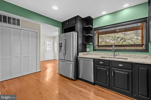 a kitchen with stainless steel appliances granite countertop a refrigerator and a sink