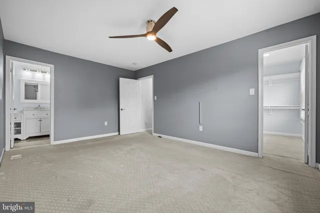 an empty room with closet and windows