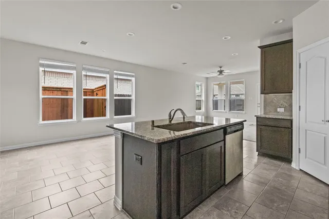 a kitchen with granite countertop a sink stove and cabinets