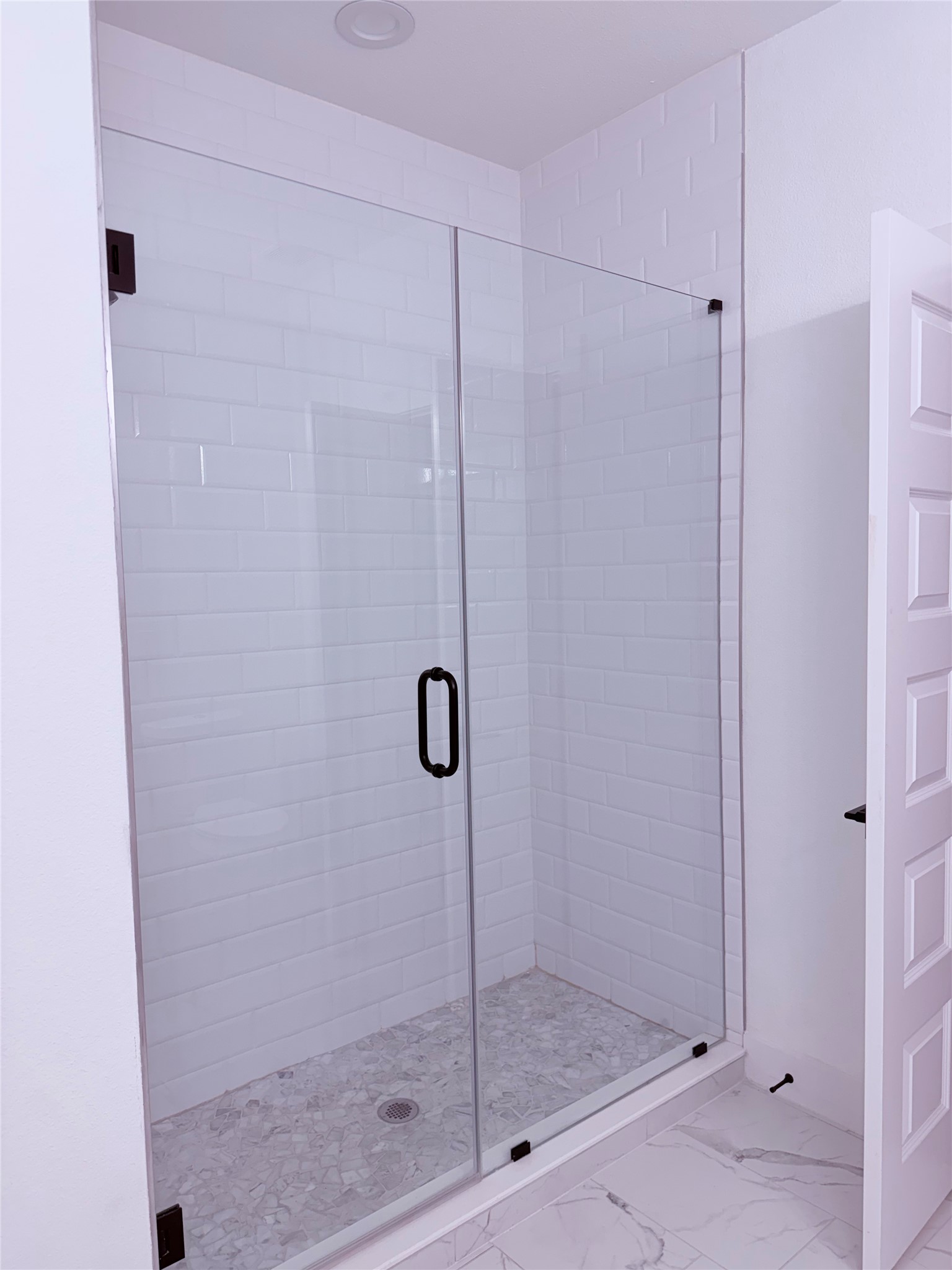 1417 Kramer Lane, Unit 7 Austin, TX 78758 - Photo 8 of 24 A pristine glass-enclosed shower boasts modern subway tile and a unique stone mosaic floor.
