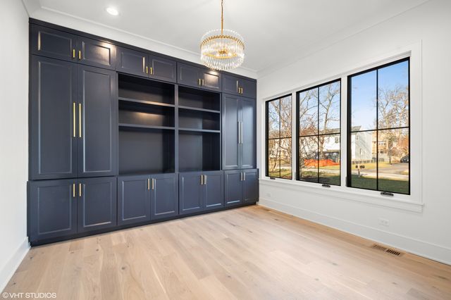 a view of an empty room with a window and cabinet