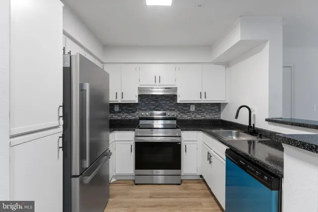 a kitchen with stainless steel appliances white cabinets and a stove