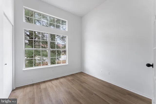 an empty room with wooden floor and shelves