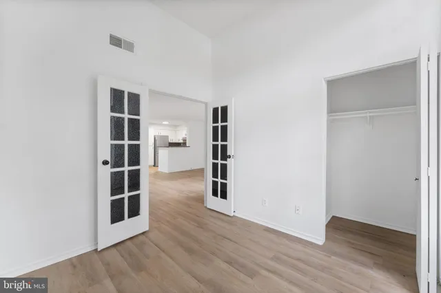 an empty room with wooden floor and windows